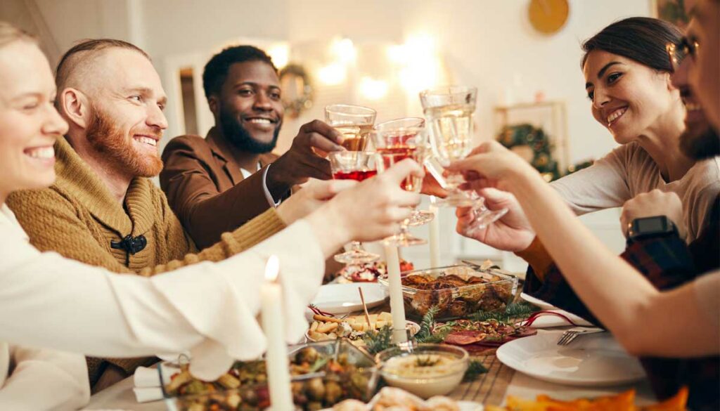 friends cheers wine glasses at holiday dinner