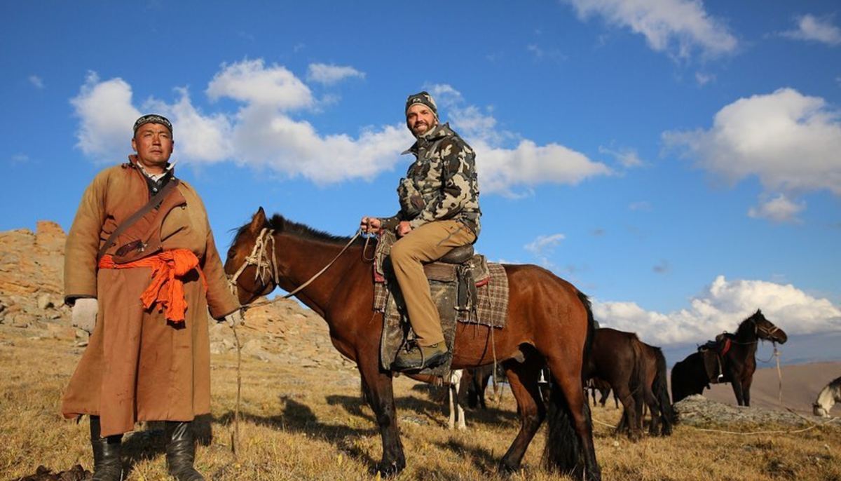 donald trump jr in mongolia on a horse, with clear open skies behind him