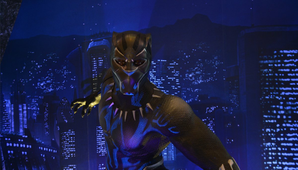 man in a black panther costume standing against the backdrop of a city skyline at night
