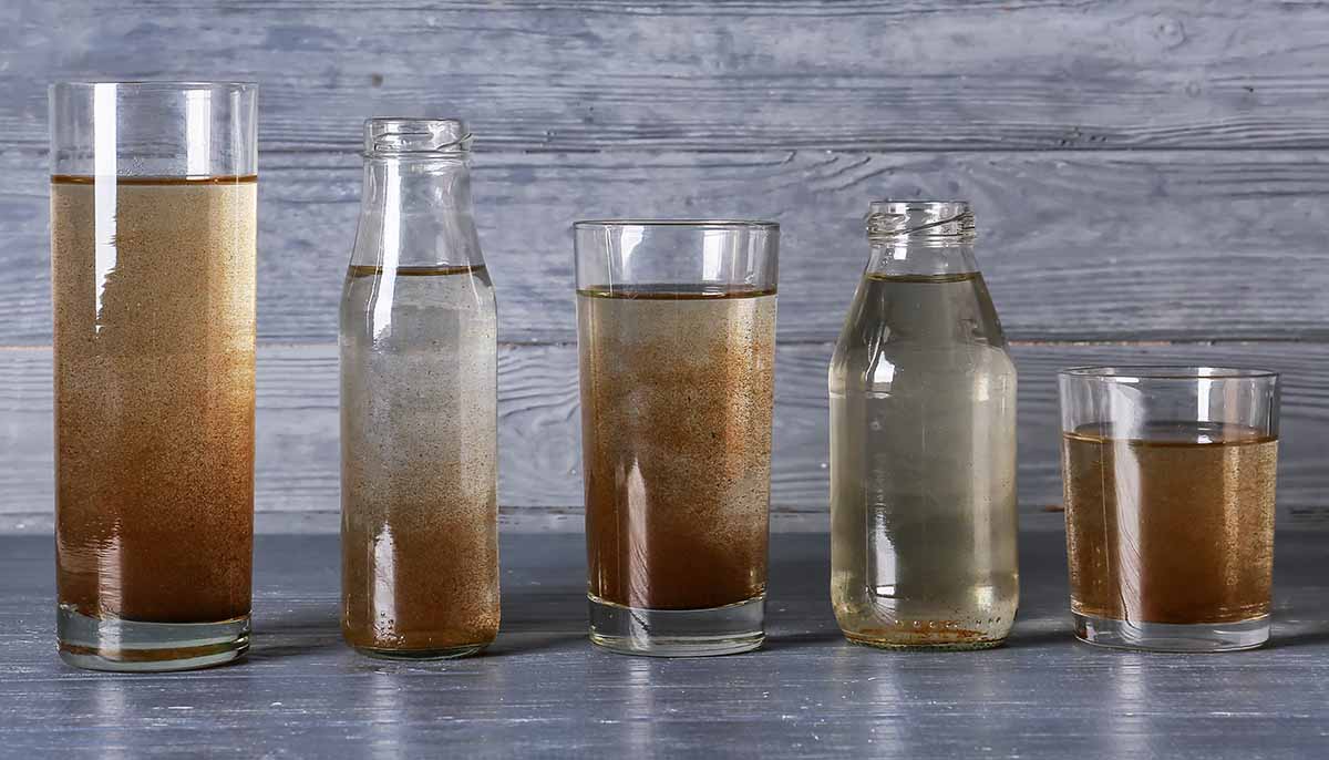 glassware with dirty water on a wooden background