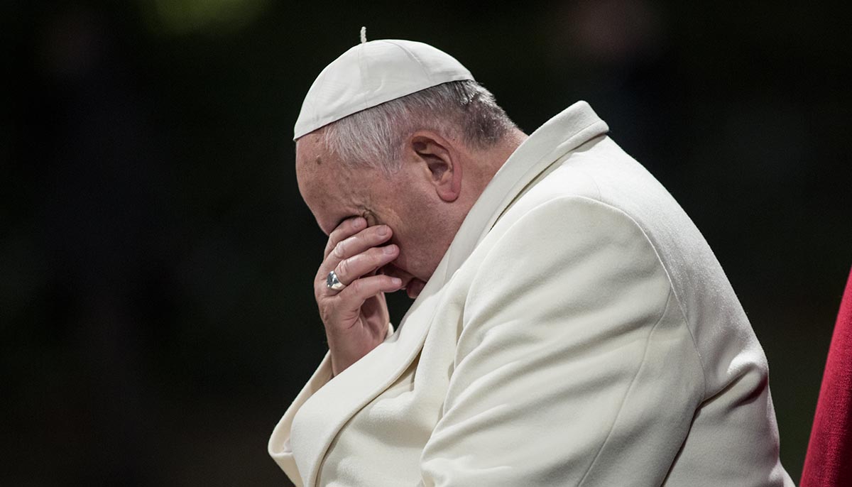 Pope Francis bows his head down while celebrating a procession at Colosseum in Rome