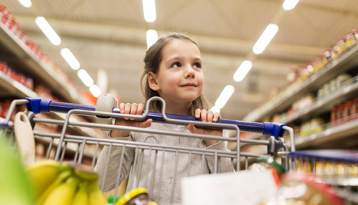 a little girl pushing a grocery cart