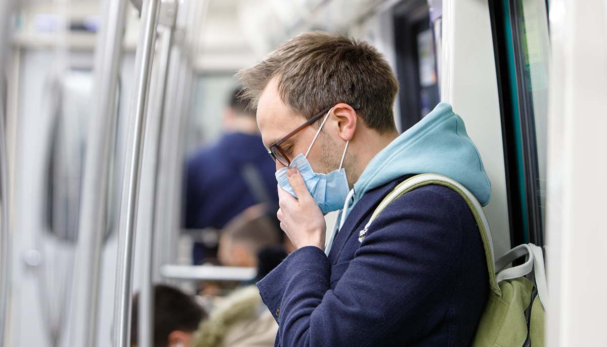 man wears face mask and feels sick inside public transport
