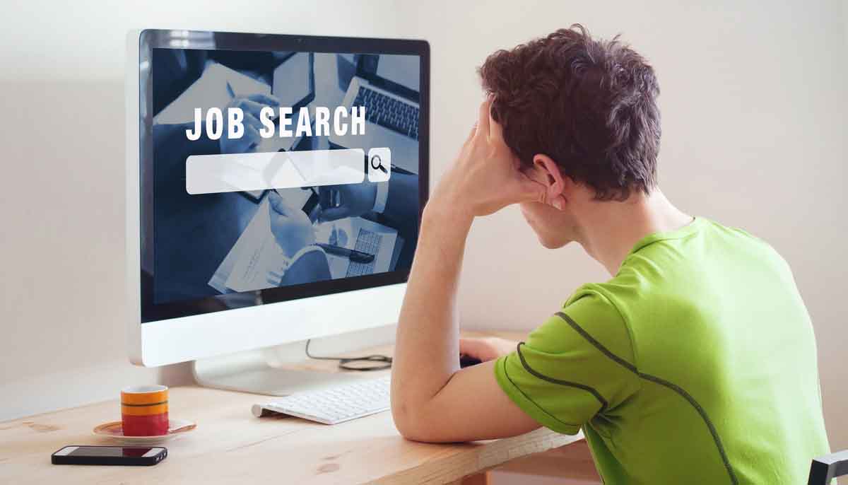 A man sitting at a computer searching for short-term employment