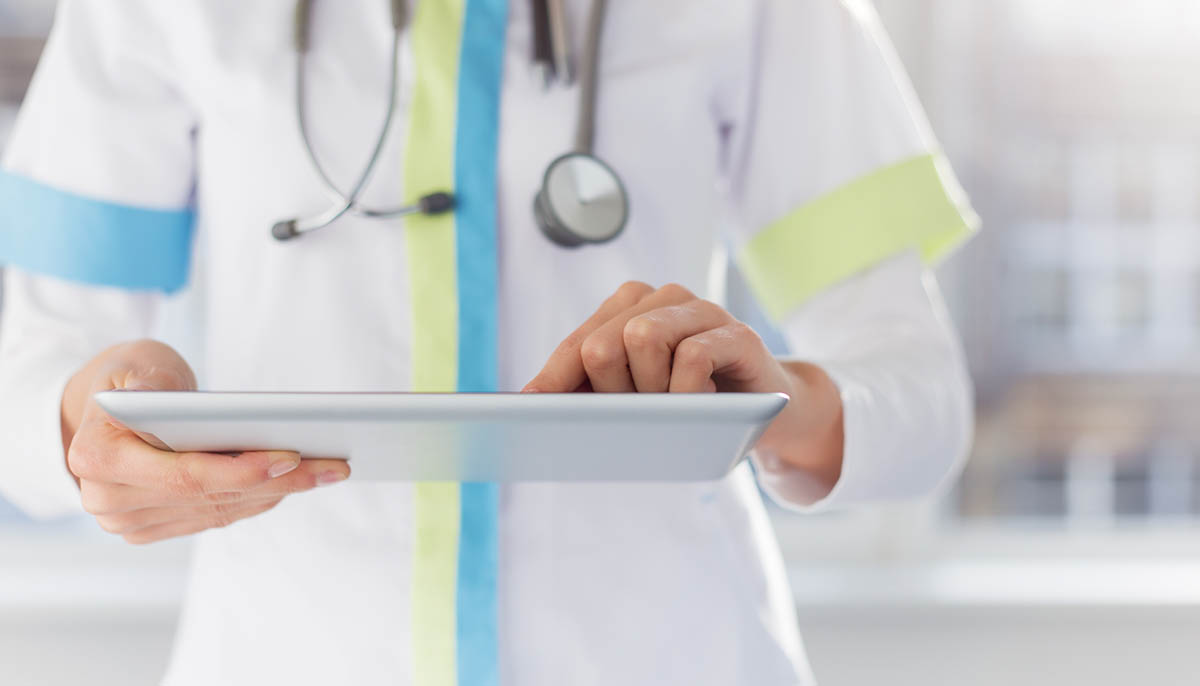 a female doctor uses an ipad in a hospital