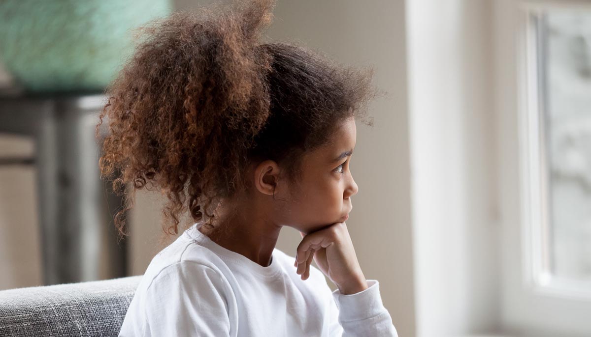 a african american girl with beautiful natural hair looks thoughtful
