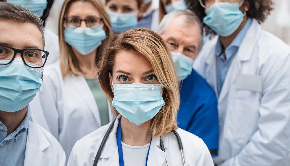 a group of doctors wearing face masks look at the camera