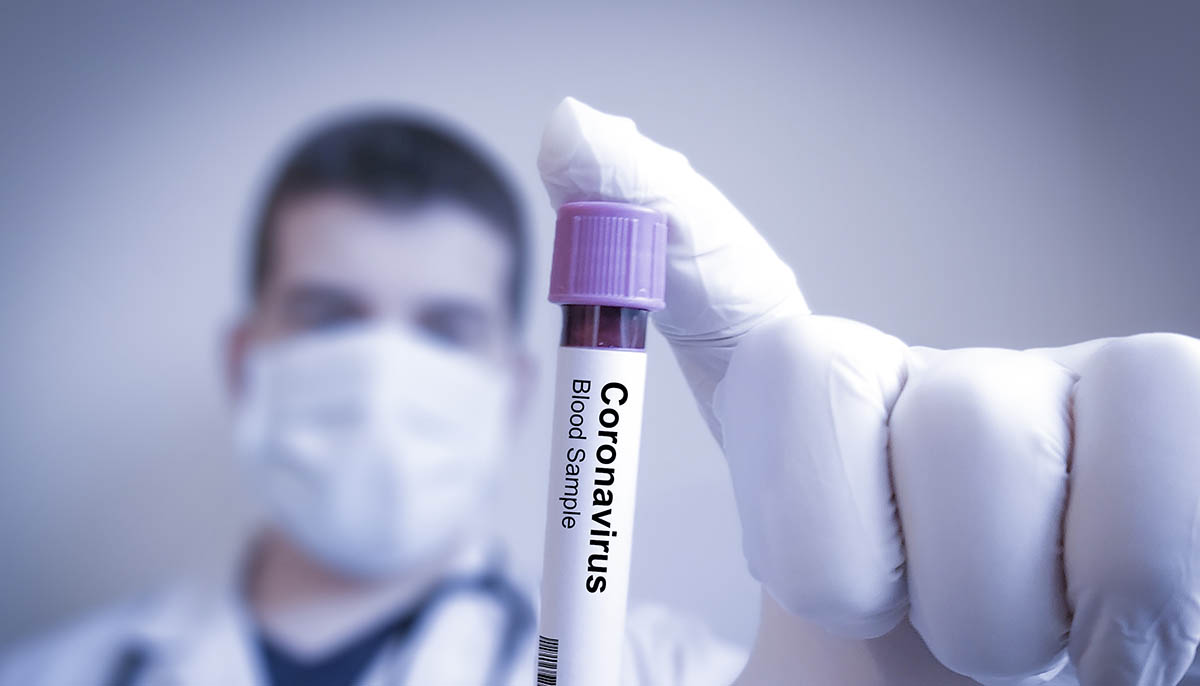  medical professional holds up a coronavirus blood sample