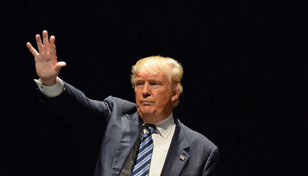 President Donald Trump raises his arm in salute