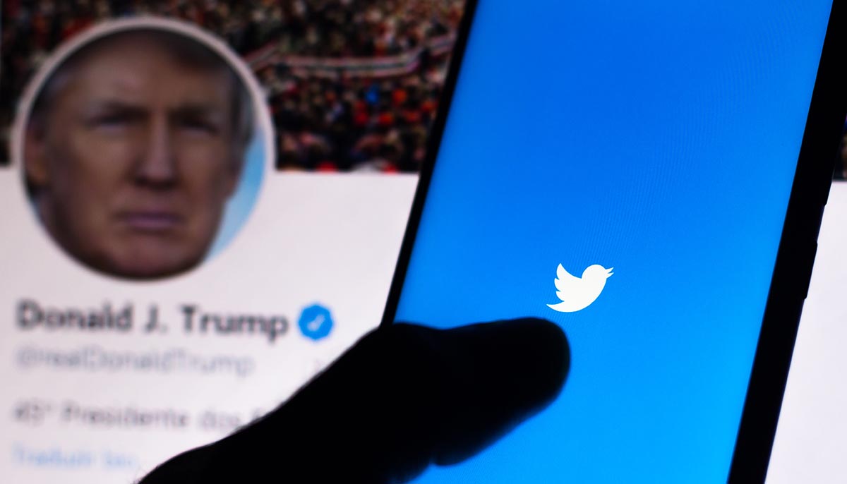 donald trump twitter profile shown with phone in foreground