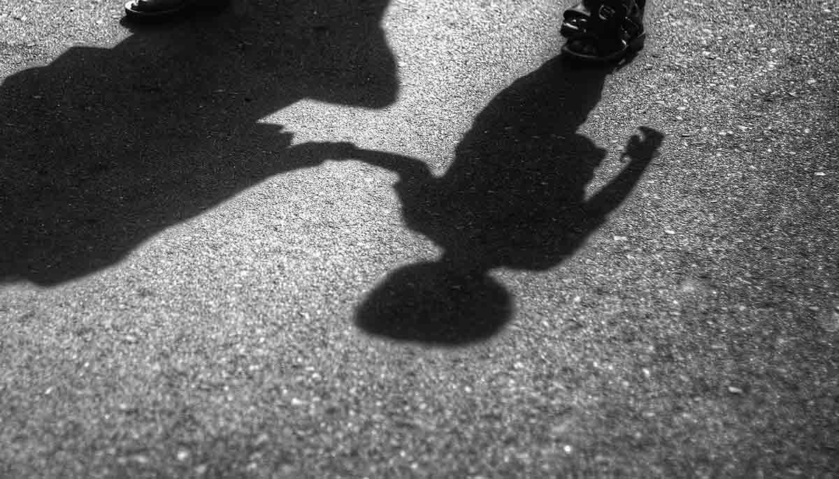  shadows of child being led away by adult