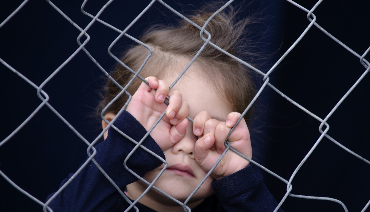 a little girl behind a fence