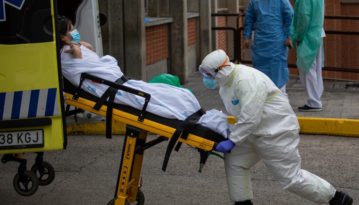 a man in a hazmat suit pushing a woman on a stretcher